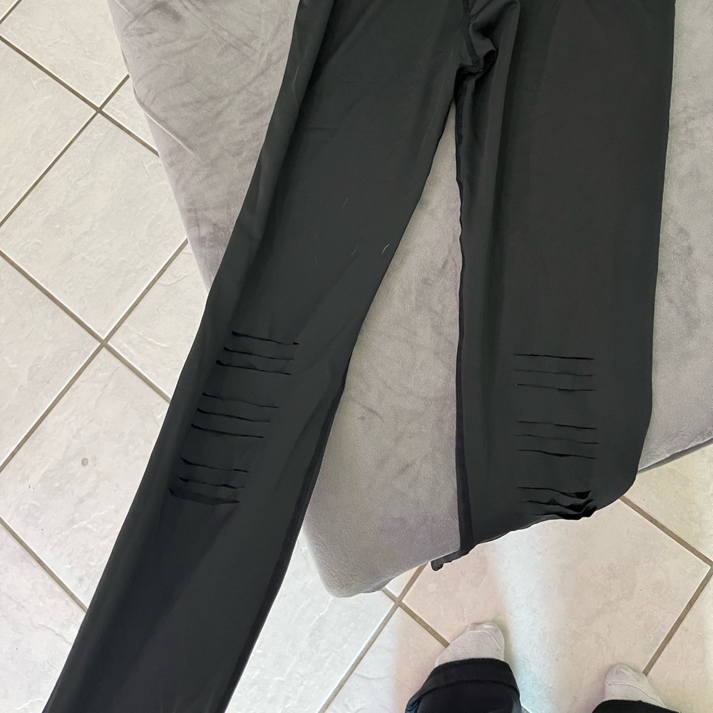 Large silky healing leggings with cuts through them that open up when you put on